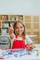 Teenage girl constructing electrical mechanism in the classroom