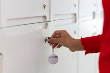 Woman holding a key opening her locker.