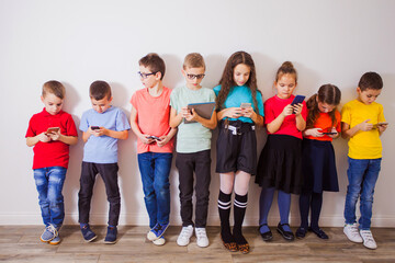 Schoolchildren with gadgets watching online live broadcasting