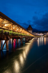 Kapellbrücke, medieval bridge in Luzern at night. The bridge is illuminated, the lights are...