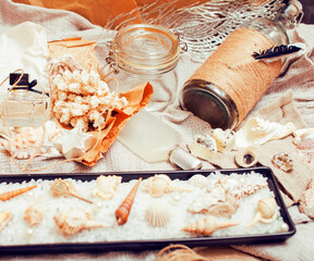 Obraz na płótnie Canvas a lot of sea theme in mess like shells, candles, perfume, girl stuff on linen, pretty textured post card view vintage