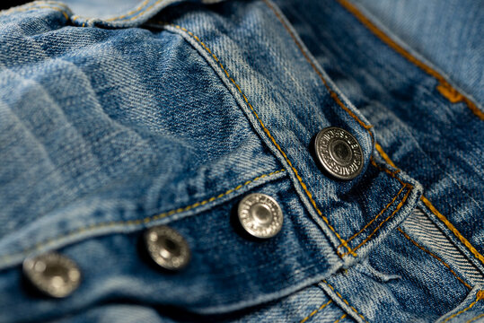 Miercurea Ciuc, Romania- 10 August 2021: Shiny buttons on Levi Strauss blue jeans close up macro shot.