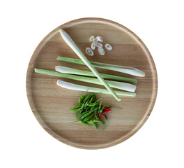 Fresh lemongrass and chilli in a wooden tray on a white background