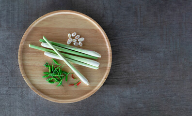 Lemongrass and fresh chili in a wooden tray on the wooden floor