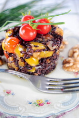 Black risotto with tomatoes peppers and walnuts