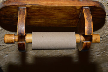 Empty toilet paper roll on a wooden hanger