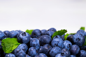 Close up of Blueberry With a Green Mint leaf on a white top view, Summer Freshly Berry, Copyspace