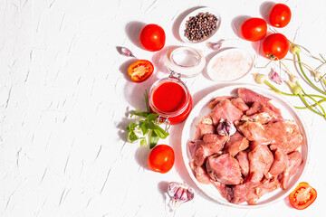 Raw pork pieces, tomatoes, spices, and herbs