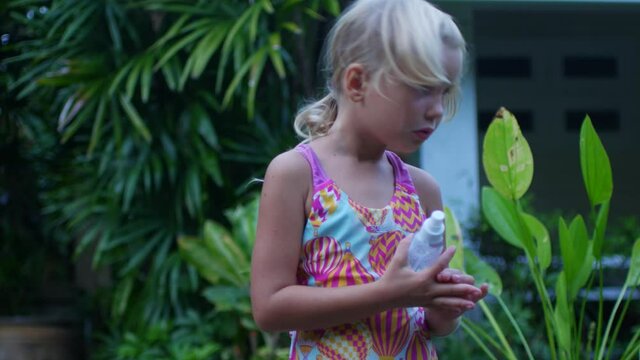 A child in the tropics treats skin with mosquito repellent
