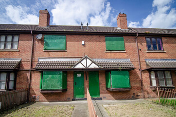 Fototapeta na wymiar Boarded-up terrace houses awaiting refurbishment local authority housing estate in the North of England.