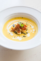 Fresh yellow pumpkin soup served with croutons