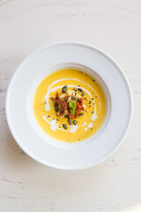 Fresh yellow pumpkin soup served with croutons