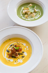 Fresh pumpkin and spinach cream soups served on a cafe table