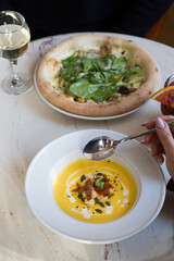 Two women having lunch at the cafe of soup and pizza