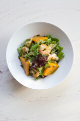 Bowl of fresh vegetarian seafood salad with pumpkin
