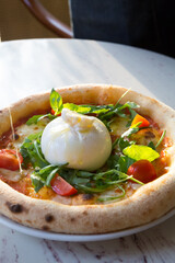 Buratta cheese on a neapolitan pizza on a table