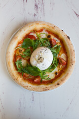 Buratta cheese on a neapolitan pizza on a table