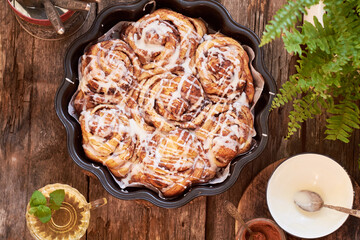 Rose cinnamon rolls. Brioche. Top view, wooden background, icing sugar, cocoa, yeast buns.