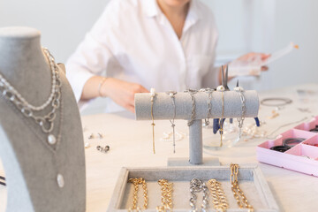 Professional jewelry designer making handmade jewelry in studio workshop close up. Fashion,...