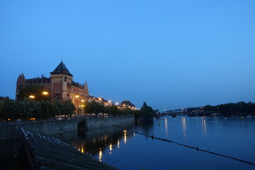 Obraz premium Sunset and night view near Charles Bridge with river view, a medieval stone arch bridge that crosses the Vltava (Moldau) river, Prague, Czech Republic