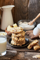 Oatmeal Chocolate Chip Cookies.  Wooden background, side view, eggs, oatmeal, flour, chocolate chips, ingredients, milk, butter, rustic.