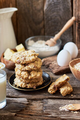 Oatmeal Chocolate Chip Cookies.  Wooden background, side view, eggs, oatmeal, flour, chocolate chips, ingredients, milk, butter, rustic.