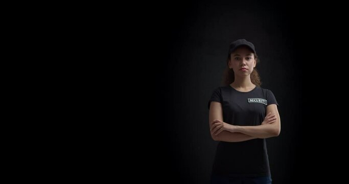 Female African-American security guard on dark background