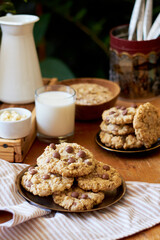 Oatmeal Chocolate Chip Cookies. Wooden table, side view, milk, chocolate, oatmeal.