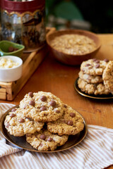Oatmeal Chocolate Chip Cookies. Wooden table, side view, milk, chocolate, oatmeal.