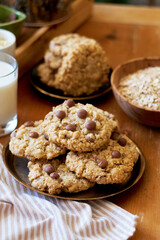 Oatmeal Chocolate Chip Cookies. Wooden table, side view, milk, chocolate, oatmeal.