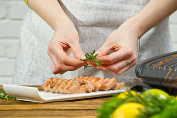 Chef hands decorating sliced fried yellow tuna fish with vegetables. blue tuna steak