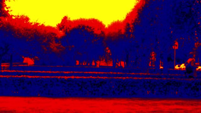 Neatly trimmed rows of bushes (bosquet) in park and strolling people. Analog of thermal image. . Blurred unrecognizable people