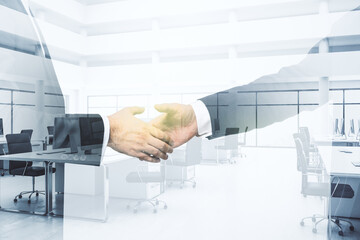 Double exposure handshake of two businessmen on modern furnished office interior background, collaboration and coworking concept