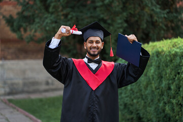 Indian graduate celebrating graduation with diploma in university campus