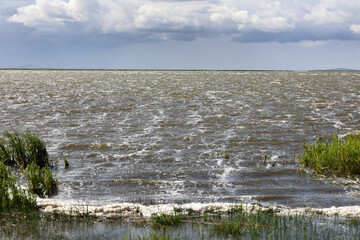 Widok na jezioro w czasie wiatru, powstały fale. 