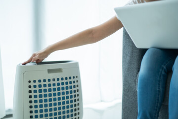 Asian woman turning on the modern air purifier while staying in the living room.