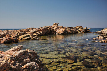 Rocks in Clear Water in Rhodes during Beautiful Sunny Day. Stones in Aegean Sea in Greece.