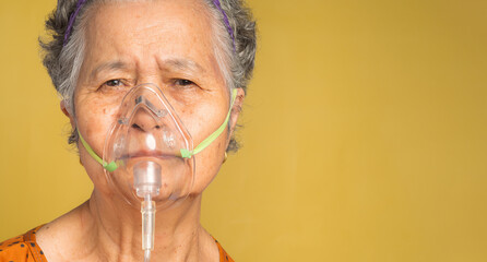 Close-up of a senior woman wearing a medical breathing mask. Sick senior woman wearing an oxygen...