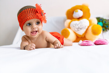 close up portrait of new born cute baby in red dress.