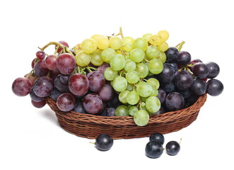 Grapes in wooden wicker basket, isolated on white background