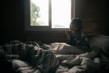 Fototapeta premium A little girl praying on the bed. Christian prayer concept.