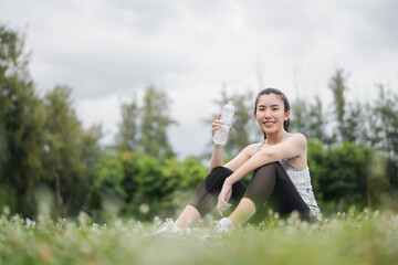 Naklejka na ściany i meble Asian women drink water after exercising