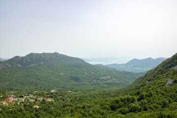 Fototapeta na wymiar National Park lake Skadar and mountains Dinar highlands of the foggy morning. The largest lake on the Balkans, Montenegro. Popular tourist destination and beautiful nature landscape.