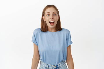 Image of surprised young woman, student drop jaw, gasping and looking in awe at camera, checking...
