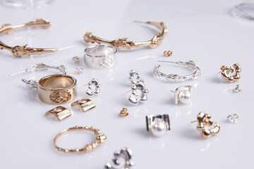 Closeup of gold and silver jewelry on a white surface