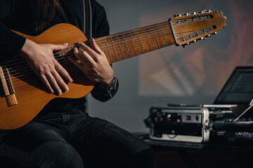 Closeup of guitarist playing an electric acoustic ten-string midi guitar during music concert