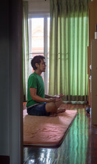 Asian man relaxing and meditating at home.Comfort zone concept