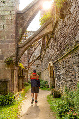 Fototapeta na wymiar A young man visiting the interior gardens of the Abbaye de Beauport in the village of Paimpol, Côtes-d'Armor department, French Brittany. France