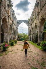 A young woman visiting the ruins of the Abbaye de Beauport church in the village of Paimpol, Côtes-d'Armor department, French Brittany. France