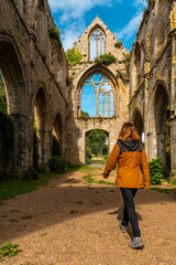 Fototapeta na wymiar A young woman visiting the ruins of the Abbaye de Beauport church in the village of Paimpol, Côtes-d'Armor department, French Brittany. France